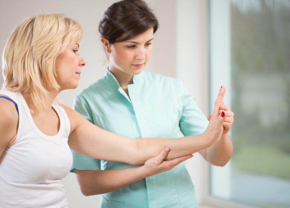 Therapist examining female patient's wrist